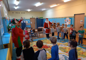 Dzieci tańczą z Mikołajem i Elfem.